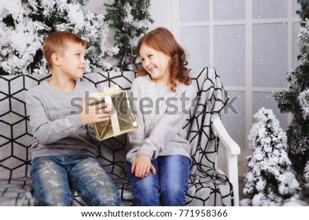 Cute happy kids, boy and girl last Christmas gift boxes . Brother and sister give Christmas gifts