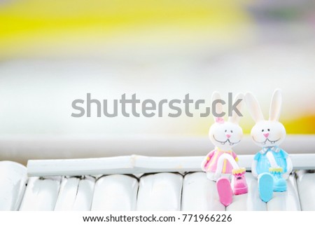 two bunny dolls sitting on wooden white