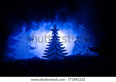 Christmas background with snowy fir trees. Snow Covered Christmas Tree stands out brightly against the dark blue tones of this snow covered scene. Toned dark background