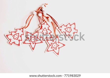 Christmas wooden toys in the form of a Christmas tree and snowflakes weigh on a rope on a white wooden background. Beautiful festive greeting card with free space