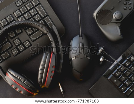 Gamer workspace concept, top view a gaming gear, mouse, keyboard, joystick, headset, on black  mouse mat background