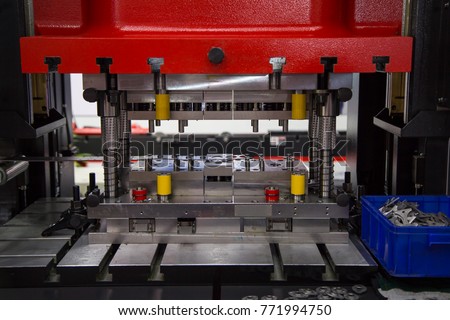 Hydraulic press stamping machine making rings in industrial factory. Royalty-Free Stock Photo #771994750