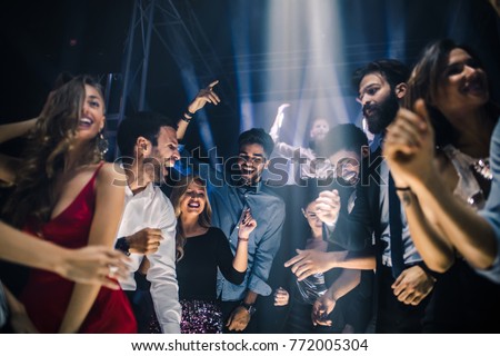 Group of friends dancing in the nightclub Royalty-Free Stock Photo #772005304