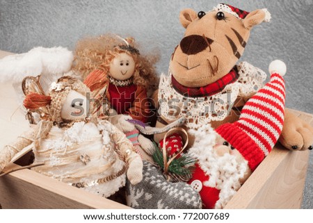 Beautiful Christmas toys, dolls and ornaments on the Christmas tree in the wooden drawer on grey shiny background