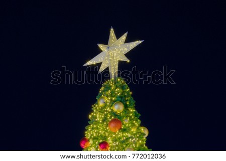 Outdoor Christmas tree, decorated with various seasonal colors, shot at night.