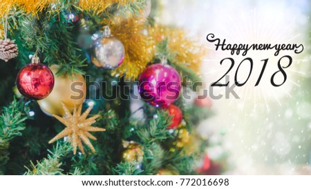 Happy new year 2018 on blurred bokeh christmas tree background with snow fall.