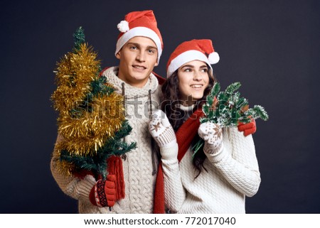 christmas tree, new year, young couple in sweaters on a black background                               