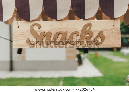 Striped outdoor kiosk with snacks in summer garden