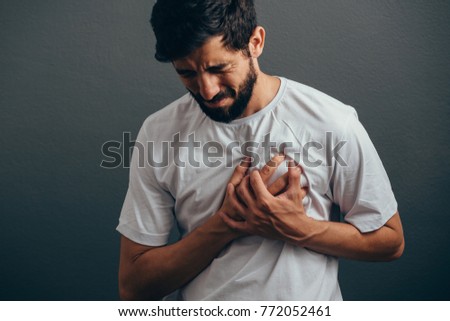 People, healthcare and problem concept - close up of man suffering from heart ache over gray background Royalty-Free Stock Photo #772052461
