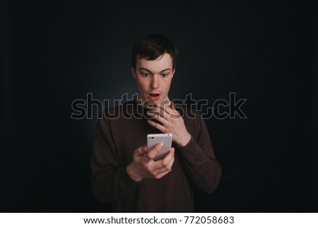Guy I saw on the screen of a mobile phone shocking news, closeup portrait in Studio