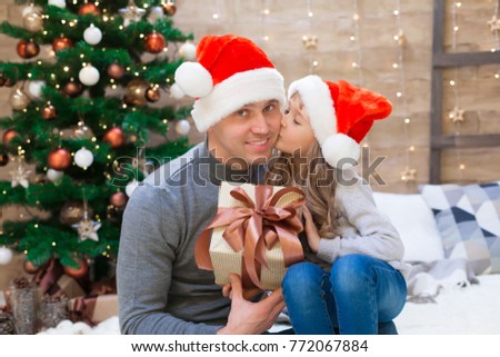 Beautiful dad and daughter, has happy fun smiling face, red Christmas hat Santa Claus, gift box. Portrait holiday. Winter background. Family kids portrait. New year decoration. 