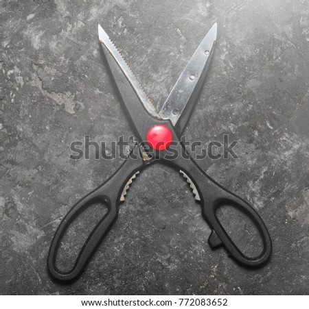 Culinary scissors on a black concrete table.