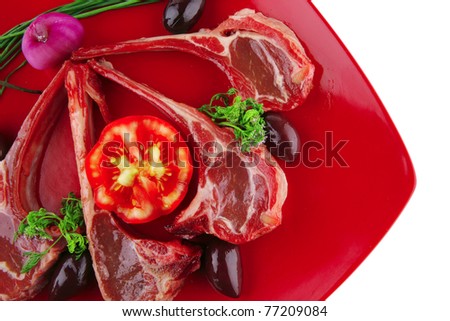 ribs served on red plate with tomatoes and greenery