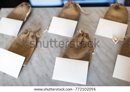 Many small brown bags of fabric and white cards.