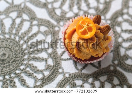 Cream caramel cupcake decorated by almonds. Modern photo