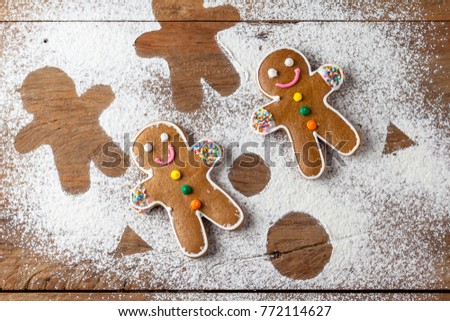 Christmas gingerbread man on a wooden table with flour silhouette around