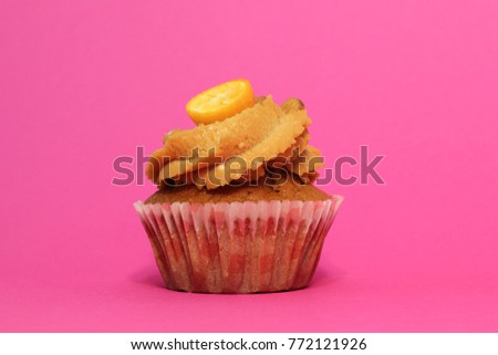 Cream caramel cupcake on pink background decorated by almonds. Modern photo