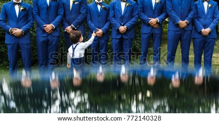 The groomsman in blue suits stand in a row. Royalty-Free Stock Photo #772140328