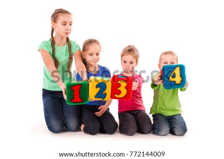 Happy kids holding blocks with numbers over white background. Teamwork concept.