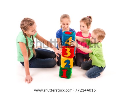 Happy kids holding blocks with numbers over white background. Teamwork concept.