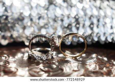 Three wedding rings on the reflecting surface with highlights.