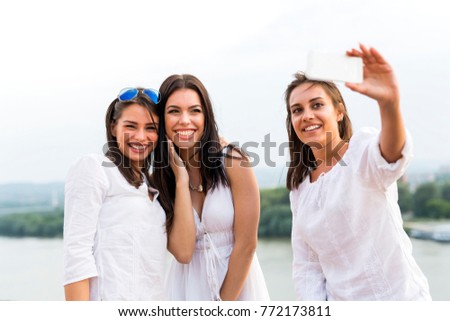 Three happy women taking a selfie of themselves