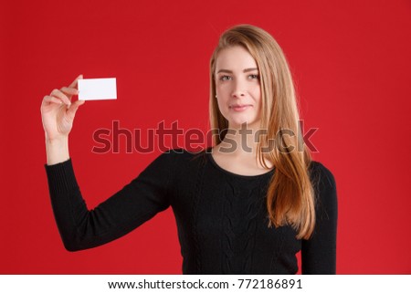 A young European girl, holding a empty business card in one hand.