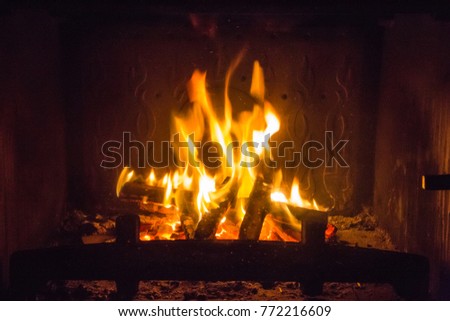 Orange flames of fire in fireplace, background, orange
