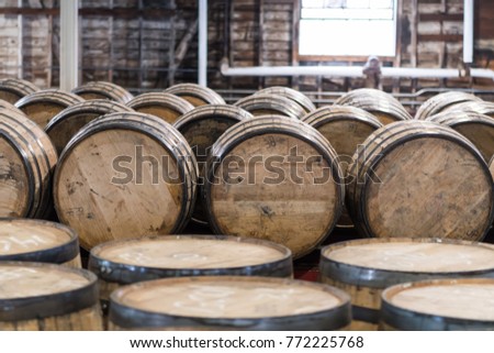 Bourbon Barrel Storage Room with barrels standing and rolling Royalty-Free Stock Photo #772225768