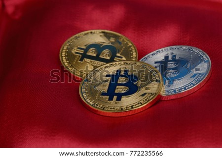 golden and silver bitcoins on the shell of soft red silk