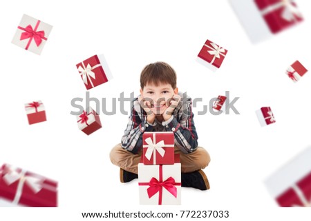 Happy smiling cute boy sitting near stack of gift boxes. Sale, finance, holiday concept. Rain of gifts isolated on white background.