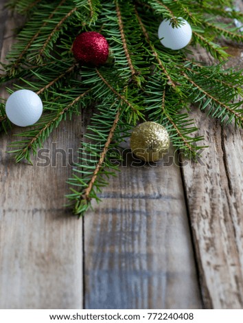 Christmas background with fir branches and decorations on old wooden table. Space for text or design. Selective focus