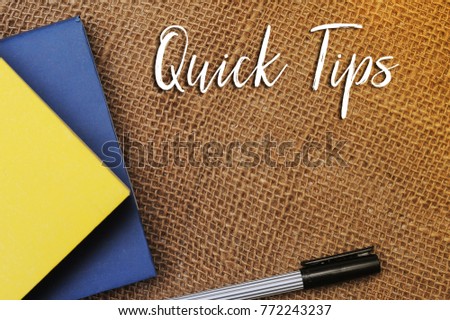 Quick Tips Concept.Book,Chalkboard,alarm clock and pen with QUICK TIPS written on vintage canvas sack background.