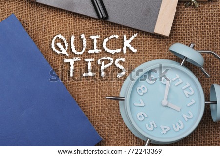 Quick Tips Concept.Book,Chalkboard,alarm clock and pen with QUICK TIPS written on vintage canvas sack background.