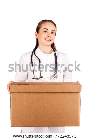 Young doctor smiling, holding box and looking at camera. image on a white studio background.