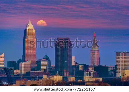 The full moon of December, a super moon, rises through clouds above downtown Cleveland, Ohio