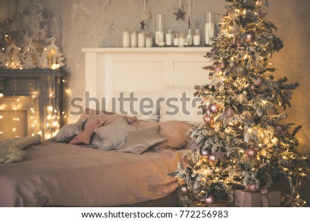 Christmas living room with a Christmas tree, gifts and bed. Beautiful New Year decorated classic home interior. Winter background