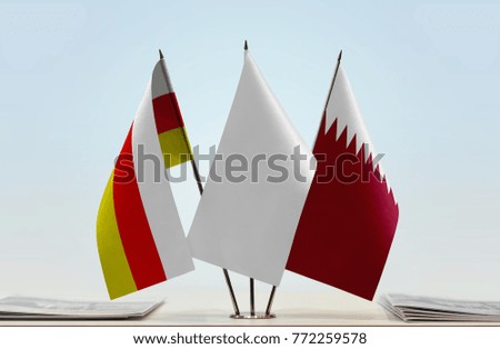 Flags of South Ossetia and Qatar with a white flag in the middle