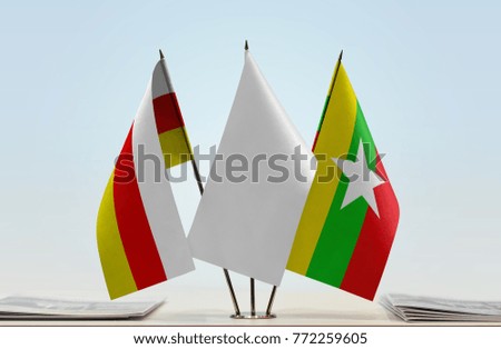 Flags of South Ossetia and Myanmar with a white flag in the middle