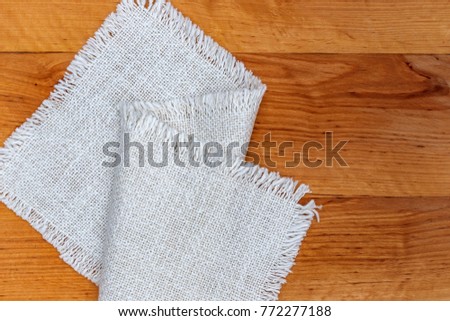 natural linen draped cloth with fringe edge on wooden table rustic background, copy space  