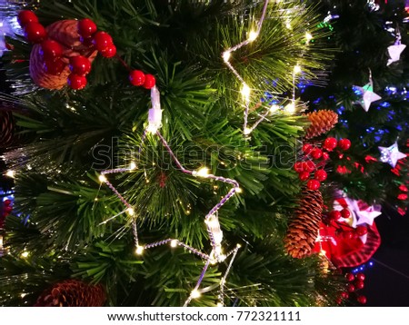 Christmas ornaments with lights hanging on a Christmas tree.