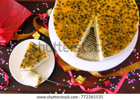 beautiful decorated served passion fruit and banana souffle cake with slice, homemade for party table preparing for family and friends, celebration background, festive table