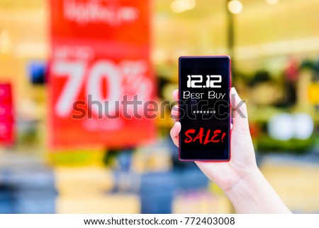 Woman hand holding mobile phone for 12.12 online shopping sale concept.