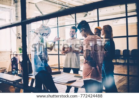 Happy group of young architects collaborating on common project working in friendly atmosphere, multiracial team having brainstorming session satisfied with creative solutions and productive job Royalty-Free Stock Photo #772424488