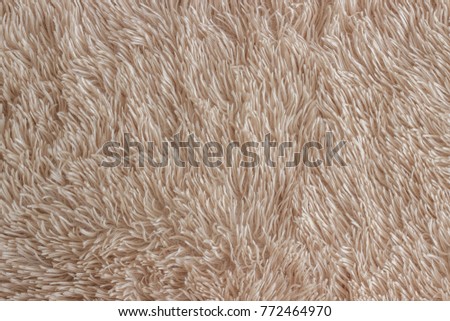 Fluffy plaid of polyester with a long pile,  beige color. Comfortable home textile. Background, texture