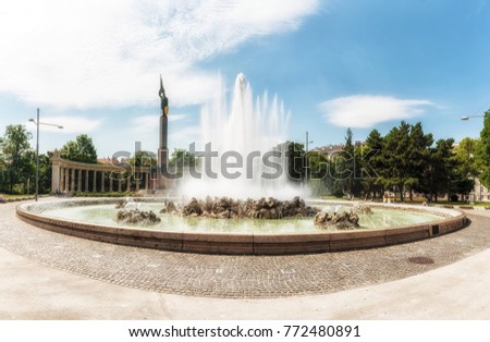 Vienna, Austria - July 9, 2017: People meander about Hochstrahl Fountain and the Soviet War Memorial in central Vienna. The Soviet War Memorial was unveiled in 1945 to commemorate the 17,000 Soviet so