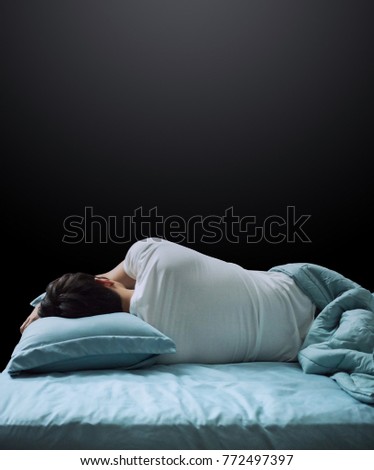 Man sleep on bed with empty grey background Royalty-Free Stock Photo #772497397