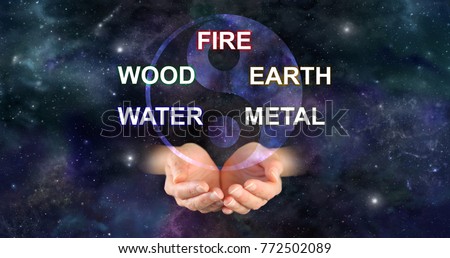 The Five Elements of Traditional Chinese Medicine -  yin yang symbol above a pair of cupped hands and the words FIRE WOOD EARTH WATER METAL against a deep space background
 Royalty-Free Stock Photo #772502089