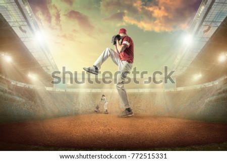 Baseball players in dynamic action on the stadium undet sunset sky with clouds.