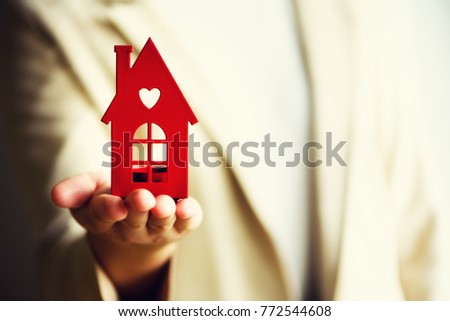 Female hand holding house key, real estate agent. Property insurance, security and cozy home concept. Copy space.